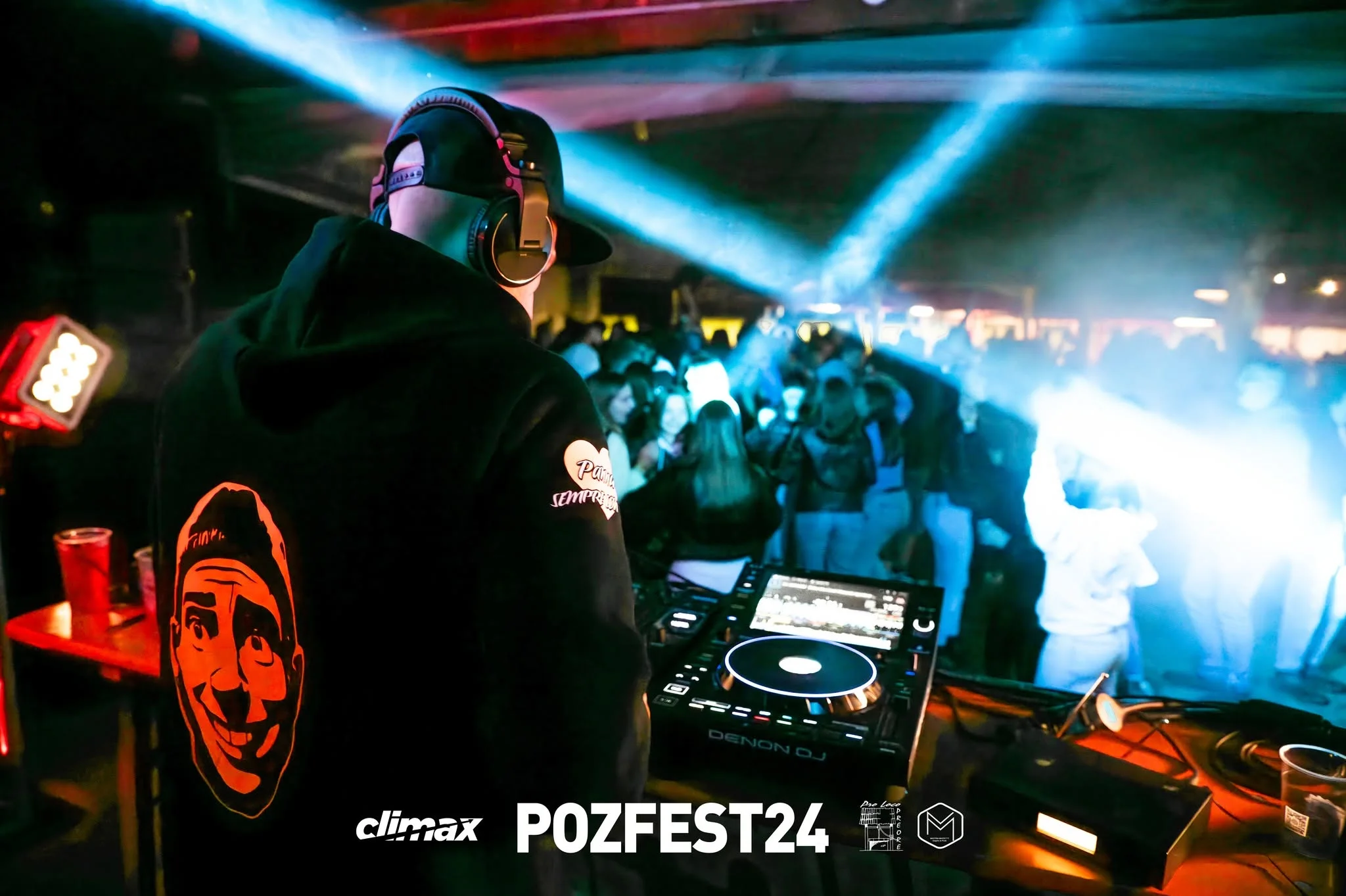 Il dj alla console del POZFEST tra i fasci di luce blu, davanti al pubblico che balla